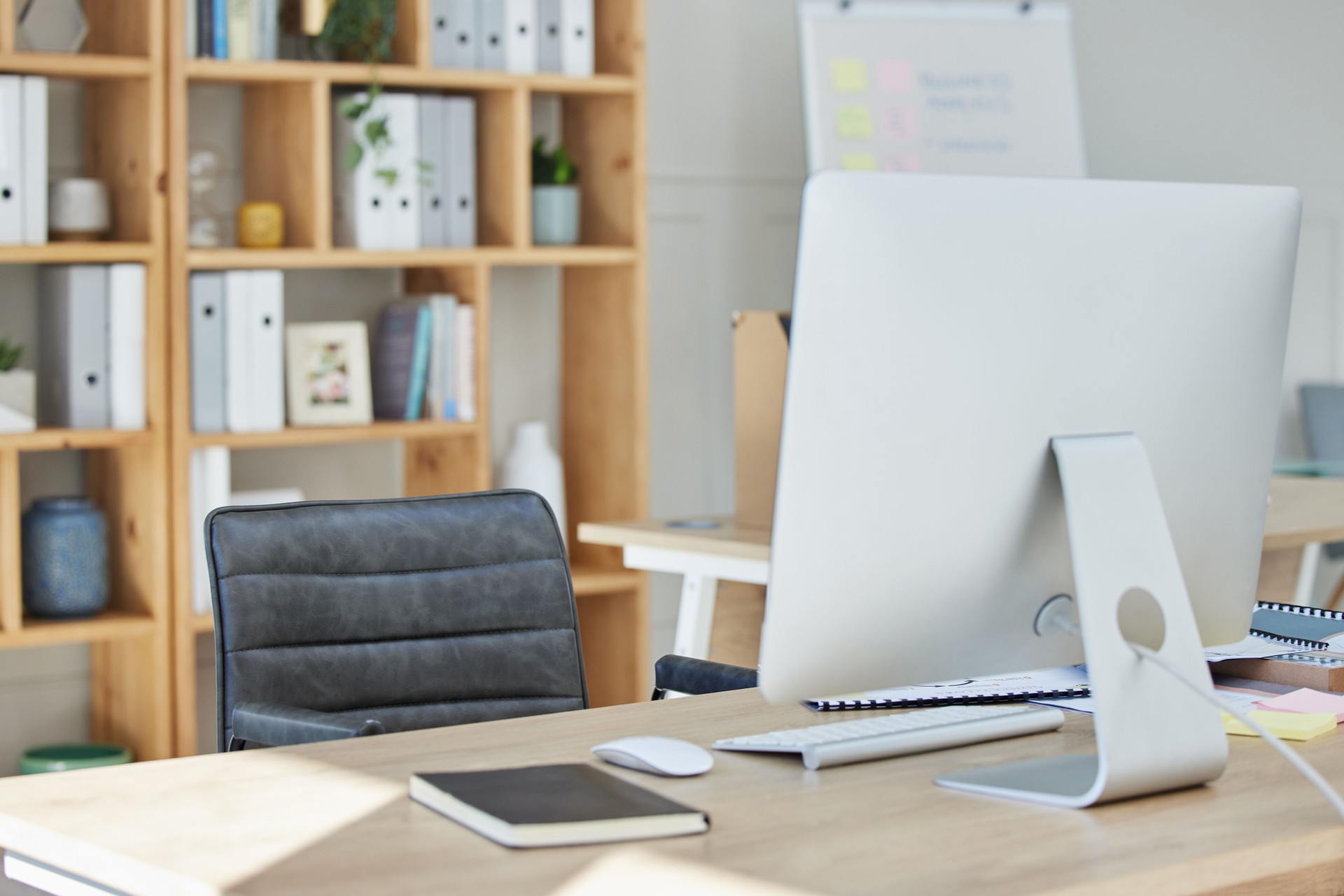 Empty office, chair and computer on desk in workplace, company or workspace room for business. Corporate furniture, modern interior or wooden table with nobody, notebook or minimal design in agency
